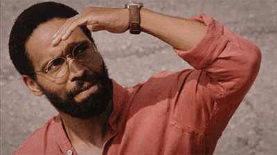 a man with a beard wearing glasses and a watch is sweating .