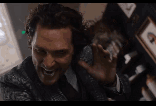 a man in a suit and tie is laughing with a green light in the background