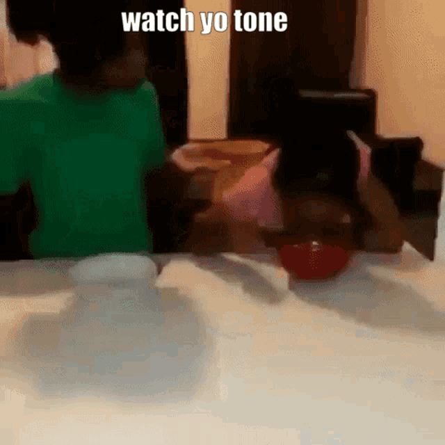 a boy and a girl are sitting at a table with a bowl of food and a caption that says watch yo tone .