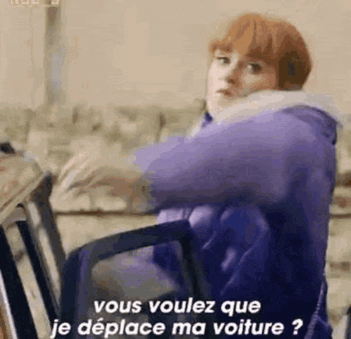 a woman in a purple jacket is sitting on a chair and talking in french .