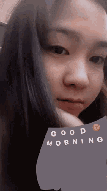 a woman with a sticker that says good morning on her face