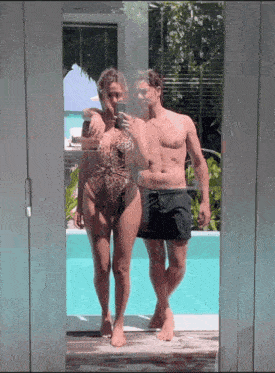 a man and a woman are taking a picture of themselves in front of a mirror