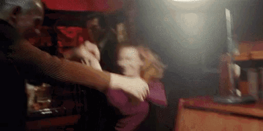a man and woman are dancing in a dark room .