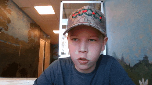 a young boy wearing a hat that says gucci