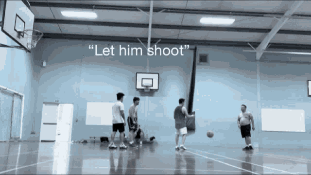a group of men playing basketball in a gym with the words " let him shoot " on the bottom