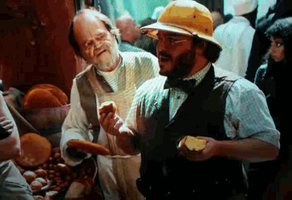 a man wearing a yellow hard hat is holding a piece of bread