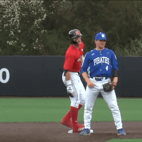 a baseball player wearing a blue pirates jersey stands on the field
