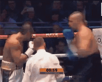 two boxers are fighting in a boxing ring with a referee in the corner and the time is 00:59