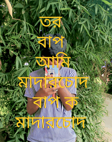 a man in a striped shirt is standing in front of a tree