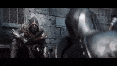 a man in a hooded armor is standing next to another man in armor .