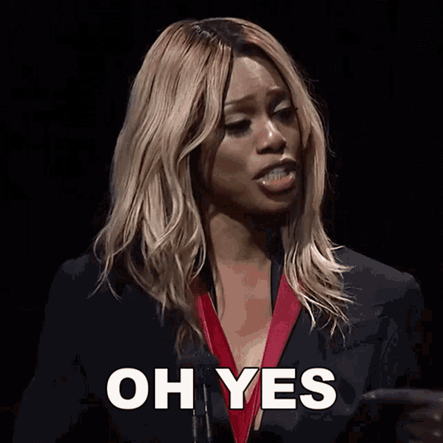 a woman with blonde hair says oh yes in front of a microphone