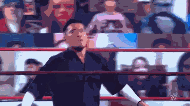 a blurry picture of a man in a wrestling ring with the w logo in the corner