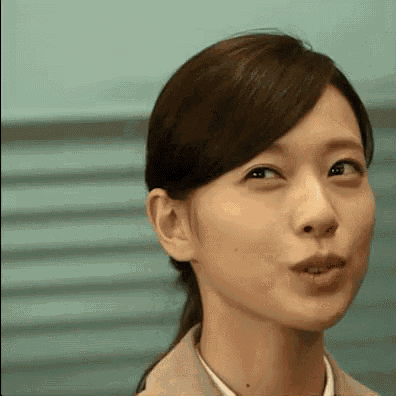 a close up of a woman 's face with her mouth open and a ponytail .