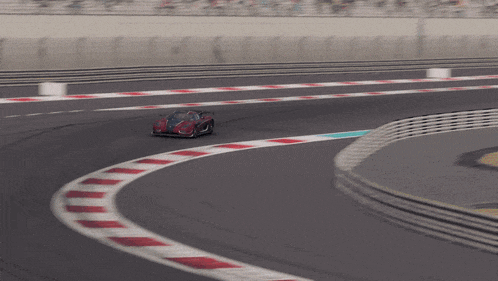 a red sports car is driving down a track
