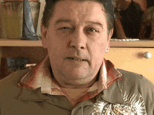 a man wearing a jacket with a tiger on it looks at the camera