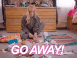 a woman is sitting on the floor in a messy room with the words go away written on the floor