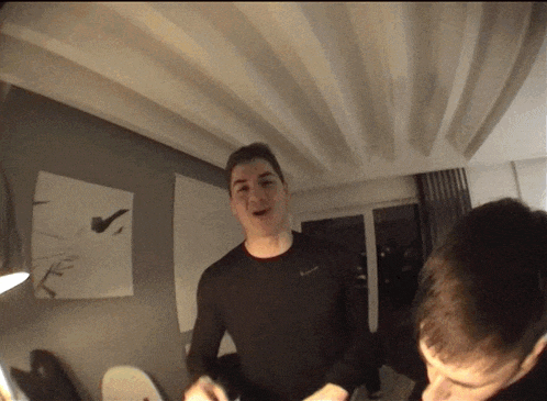 a man in a black columbia shirt stands in front of a mirror