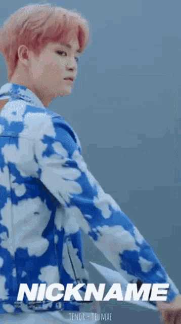 a man with pink hair is wearing a blue and white jacket that says nickname on the bottom