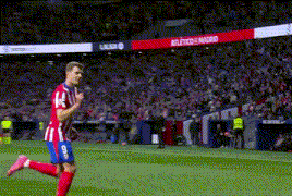a soccer player in a red and white striped uniform is running on the field .