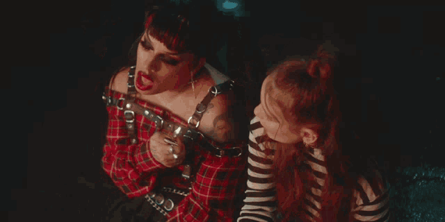 a woman with a tattoo on her arm is sitting next to another woman