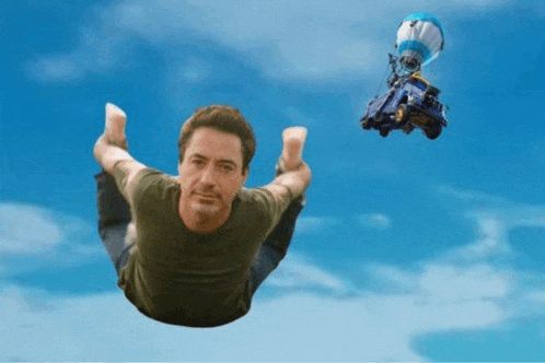 a man is flying through the air with a parachute in the background
