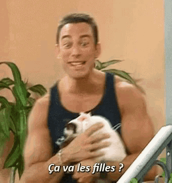 a man is holding a cat and says ca va les filles .