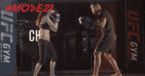 a woman is kicking a man in the face in a boxing ring with the words champ in the background