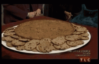 a plate of chocolate chip cookies on a table with tlc on the bottom