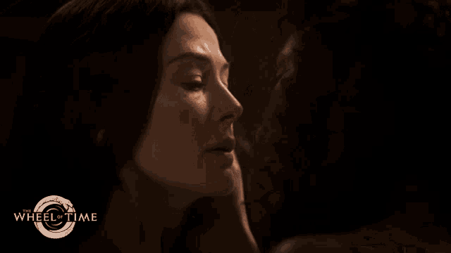 a poster for wheel of time shows a man kissing a woman on the cheek