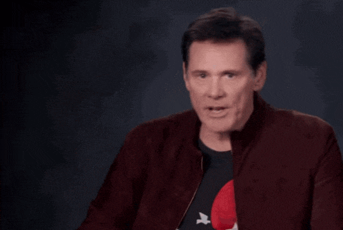 a man wearing a rolling stones shirt is making a funny face
