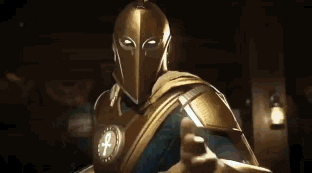 a man in a gold helmet and armor is standing in a dark room in front of a lantern .