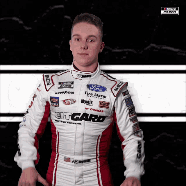 a young man in a ford racing suit stands in front of a black and white background
