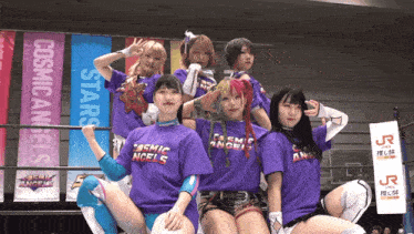 a group of women wearing cosmic angels shirts pose for a picture