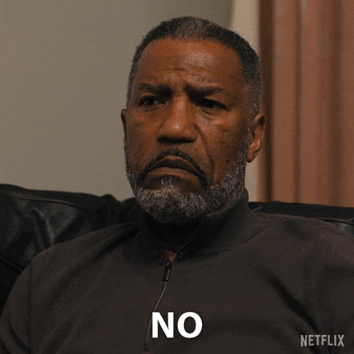 a man with a beard is sitting on a couch with a netflix logo behind him