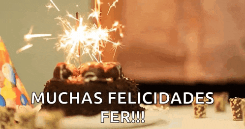a birthday cake with a sparkler on top and the words muchas felicidades fer written below it