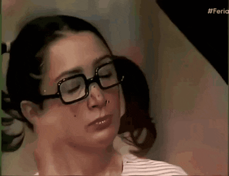 a woman wearing glasses is making a funny face .