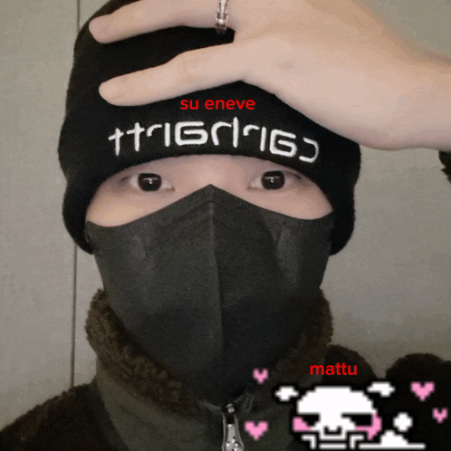 a person wearing a mask and a beanie with the word su eneve on it