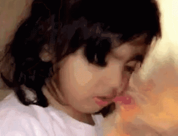 a close up of a little girl with her eyes closed .