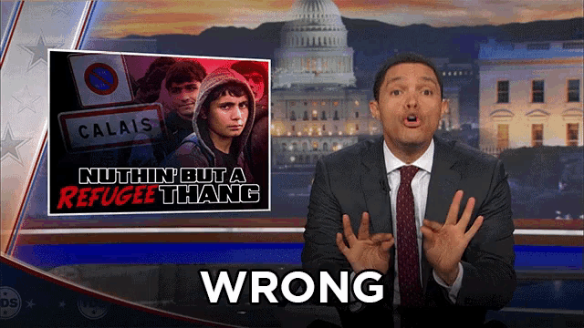 a man in a suit and tie stands in front of a poster that says wrong