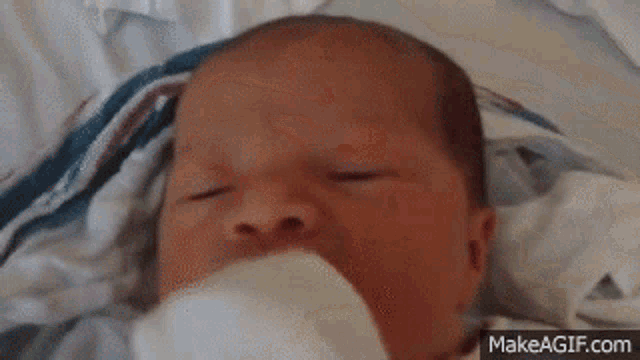a baby is laying on a bed with his mouth open