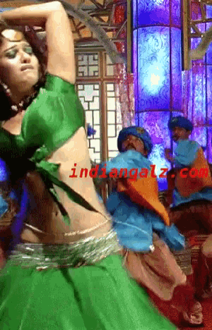 a woman in a green top is dancing in front of a sign that says indiangalz