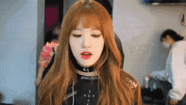 a girl with red hair is wearing a choker and a black shirt that says t nun lc