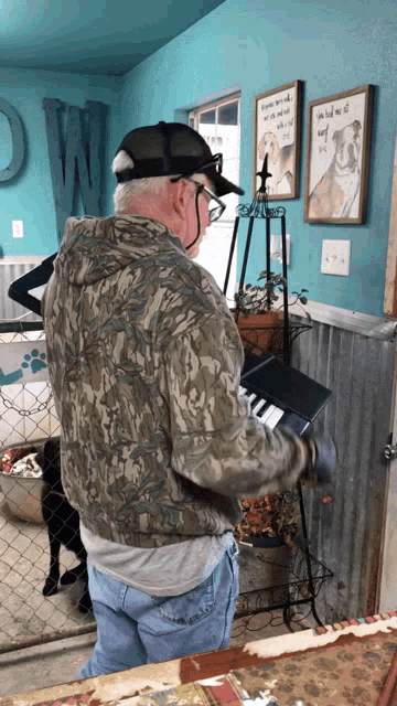 a man in a camo jacket is playing a keyboard