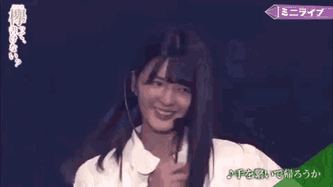 a young woman with long hair is wearing a microphone and smiling .