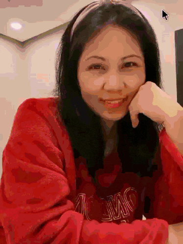 a woman wearing a red sweater with the word ac on it smiles for the camera