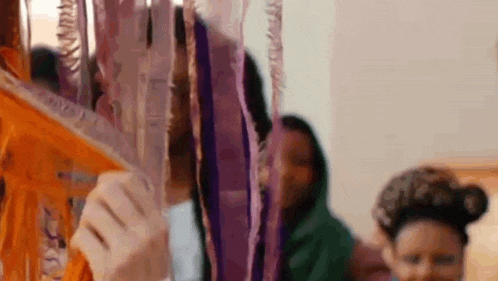 a group of children are playing with ribbons and balloons at a birthday party .
