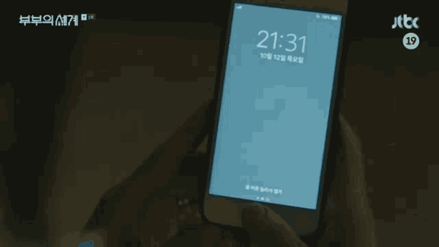 a person is holding a cell phone that says jtbc on the bottom right