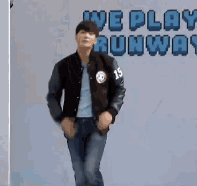 a man in a varsity jacket is dancing in front of a sign that says we play runway .
