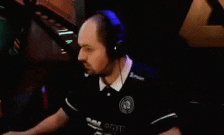 a man wearing headphones is sitting in a dark room with his arms outstretched .