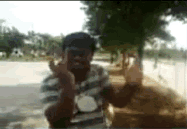 a blurry picture of a man making a peace sign with his hands